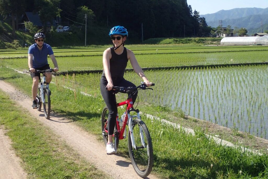 Two tourists wearing safety helmets smiling.