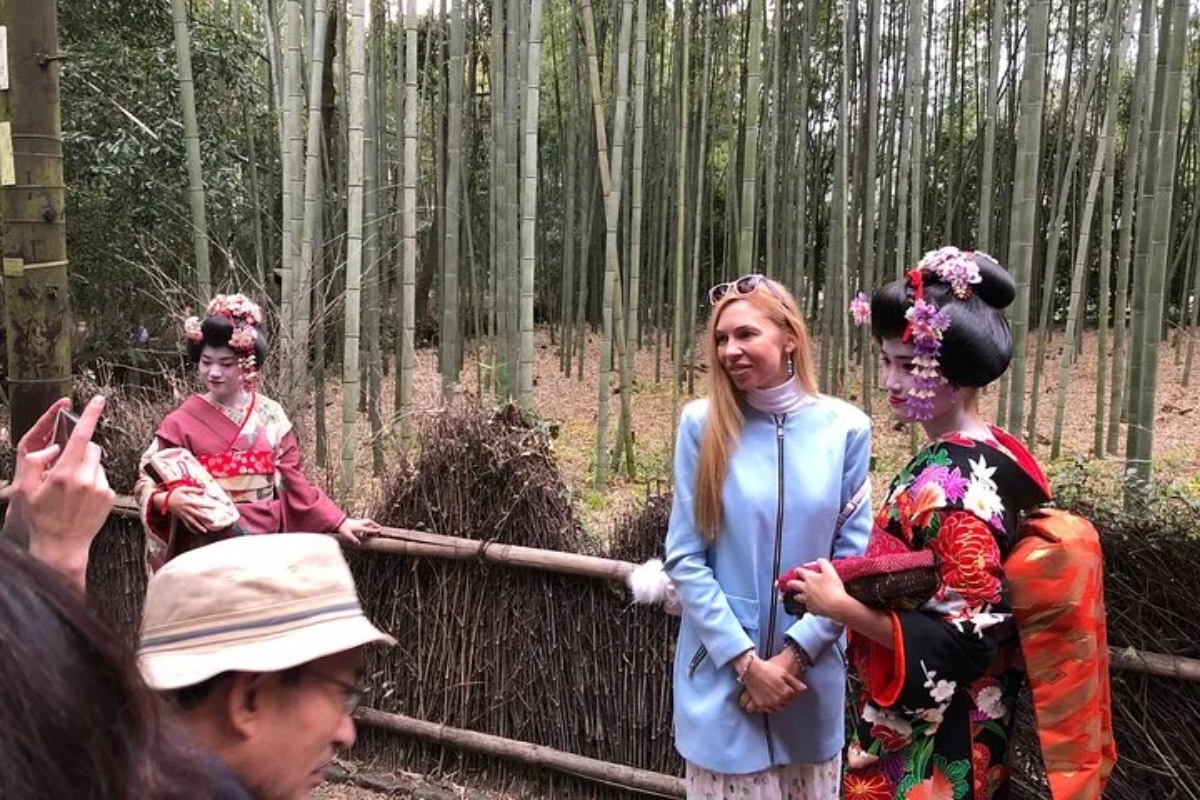 Travelers meeting maiko in Arashiyama bamboo grove during a private full-day Kyoto tour