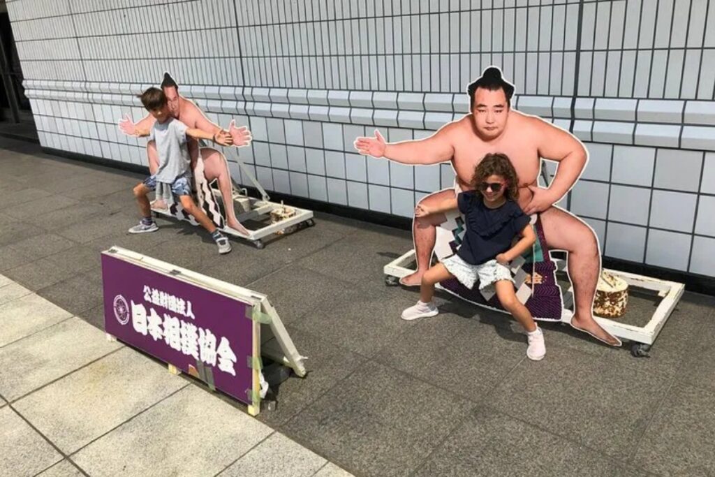 Children enjoying the sumo photo spot in Ryogoku, Tokyo