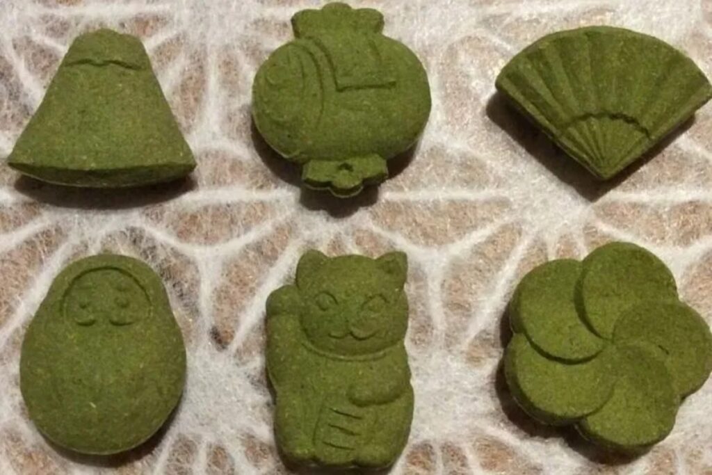 Playful green tea cones shaped like traditional Japanese lucky charms, handcrafted during an eco-friendly Uji matcha incense workshop.
