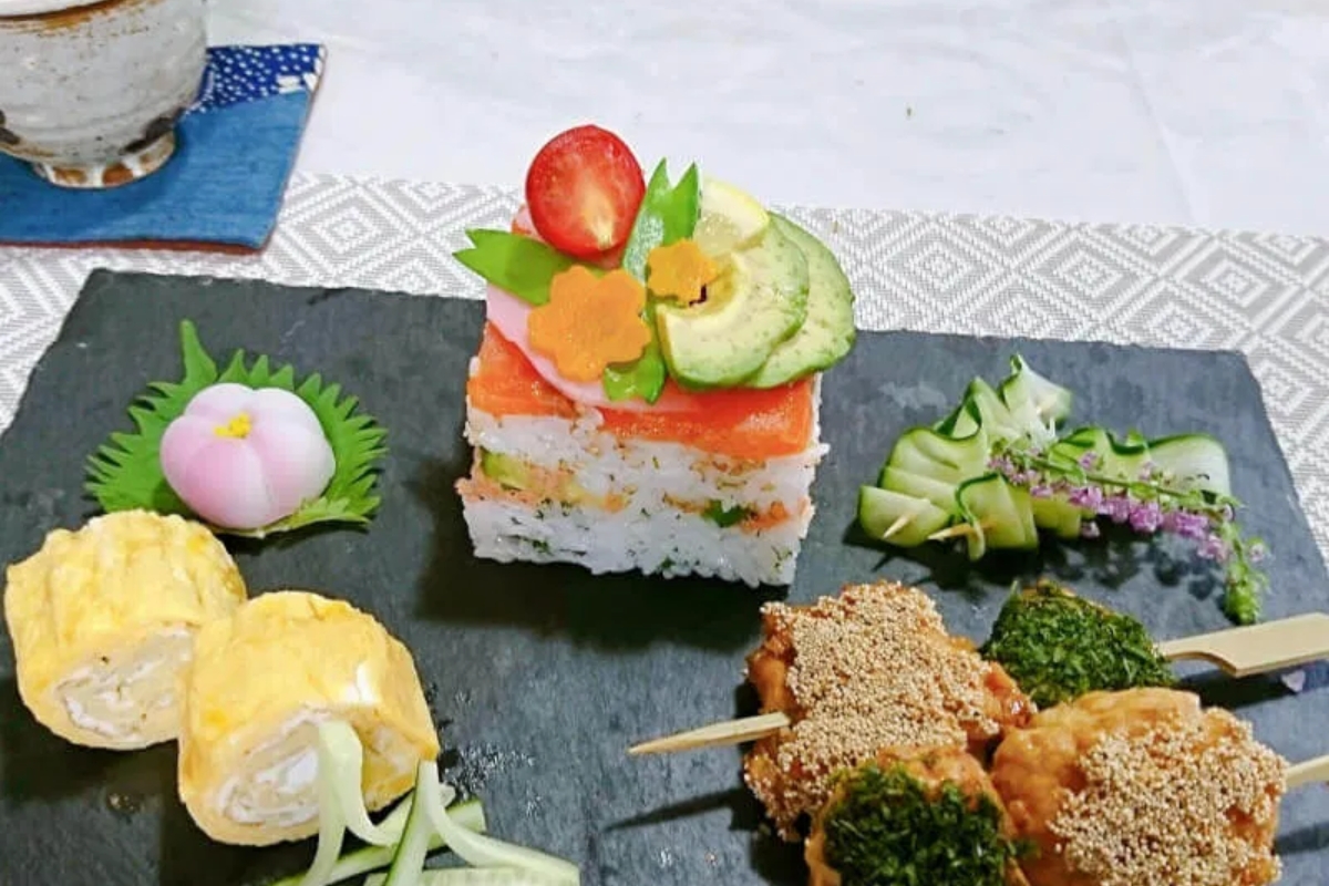 Beautifully plated colorful Oshizushi with tamagoyaki and chicken tsukune from a Tokyo sushi cooking class