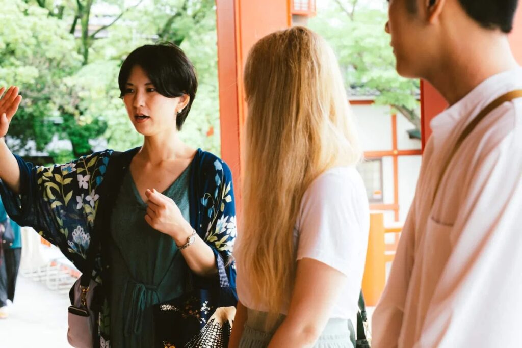 Local guide Manami sharing temple etiquette with international guests on a Tokyo guided tour