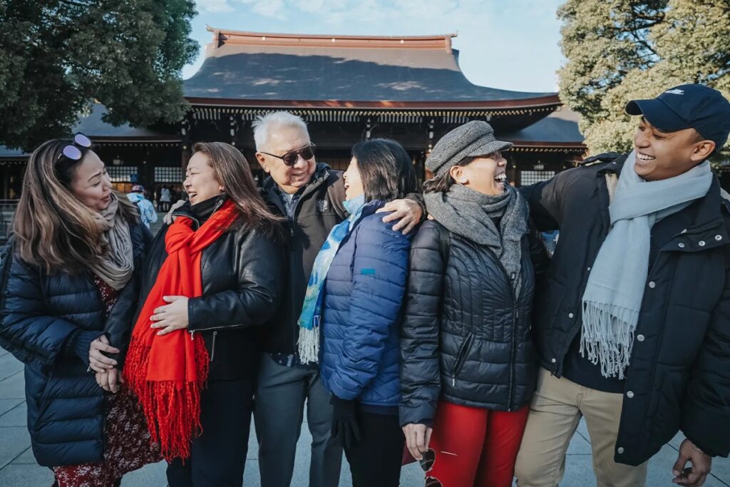 Happy family laughing together in front of a Tokyo shrine during a private group photoshoot