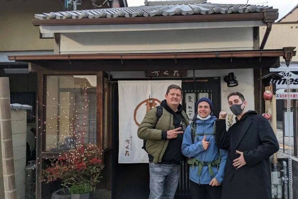 A group of friends smiling outside a traditional local shop during a Nara food walking tour.