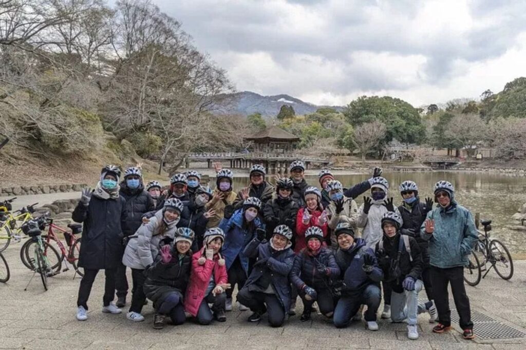 A big group of travelers gathered together for a memorable photo in a scenic outdoor park