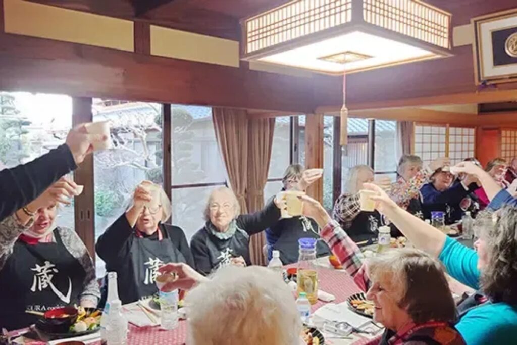 Group of happy guests raising a toast around the table in a traditional Japanese home in Nagoya