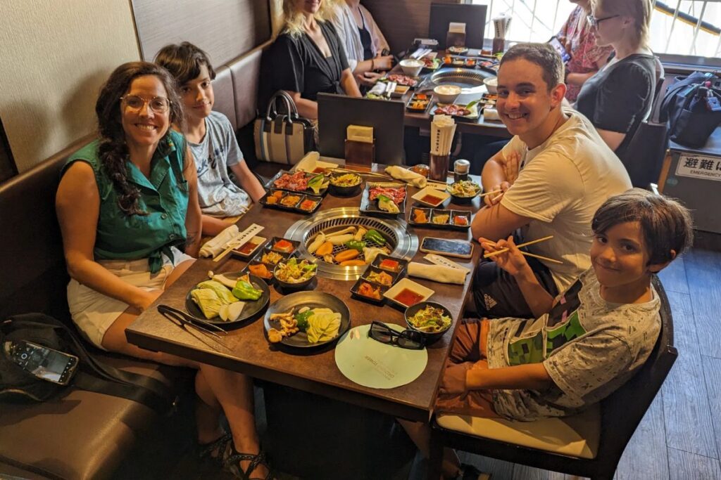 Friends sitting around a restaurant table sharing a delicious traditional meal together.