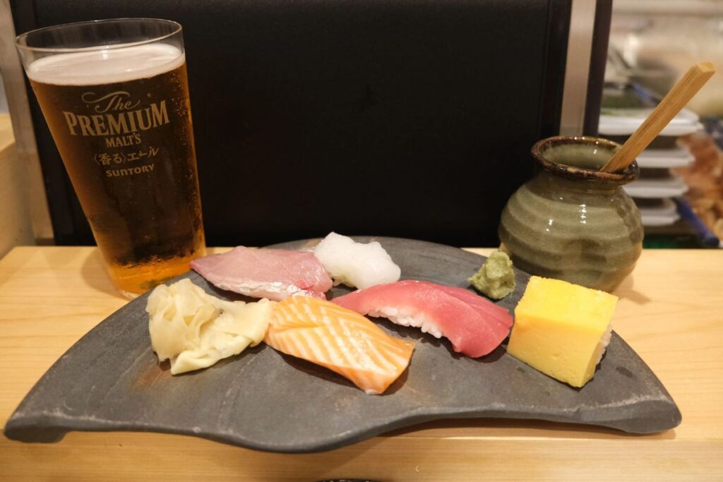 A delicious plate of traditional sushi and a refreshing beverage enjoyed on an Osaka history food tour.