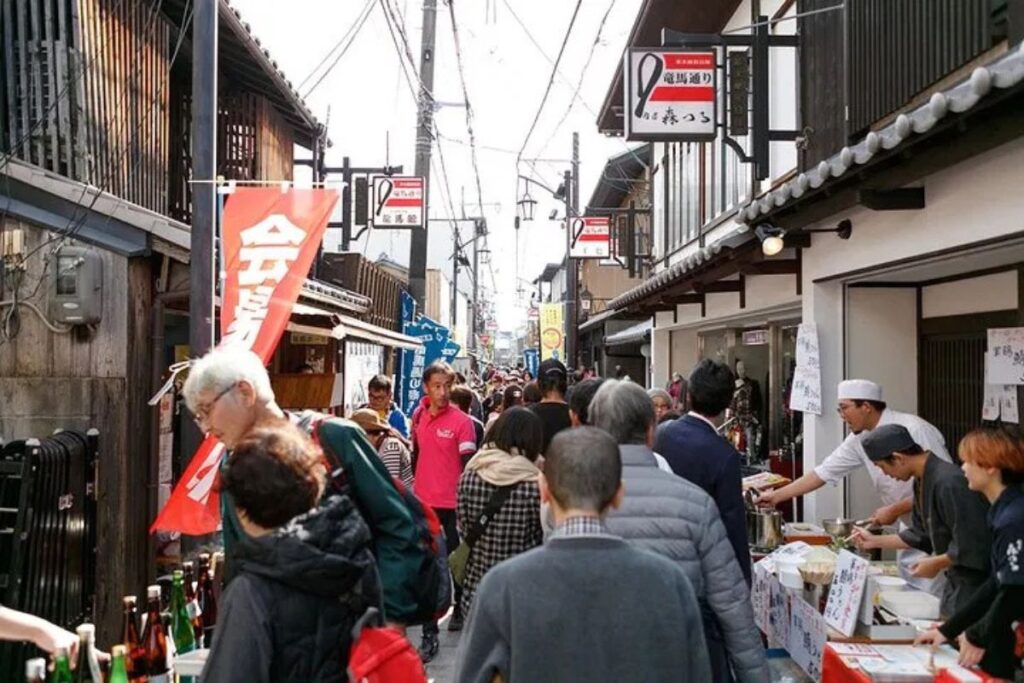 A crowded traditional shopping street explored on a Kyoto Fushimi food tour.