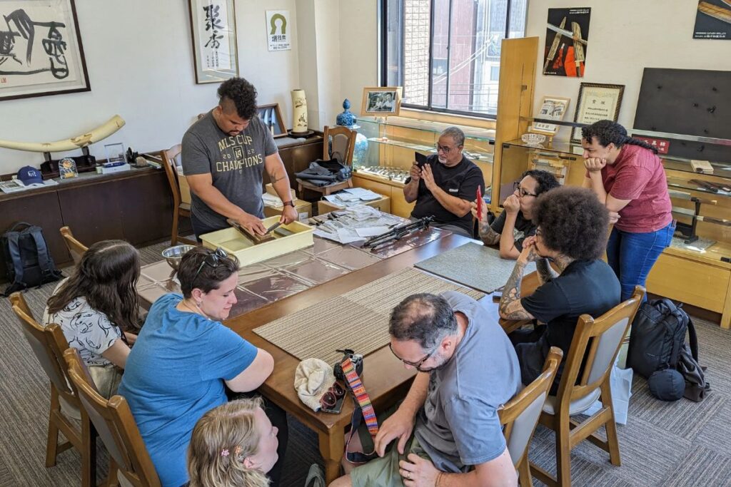 Guests watching a traveler sharpen a blade on a private sakai knife tour.