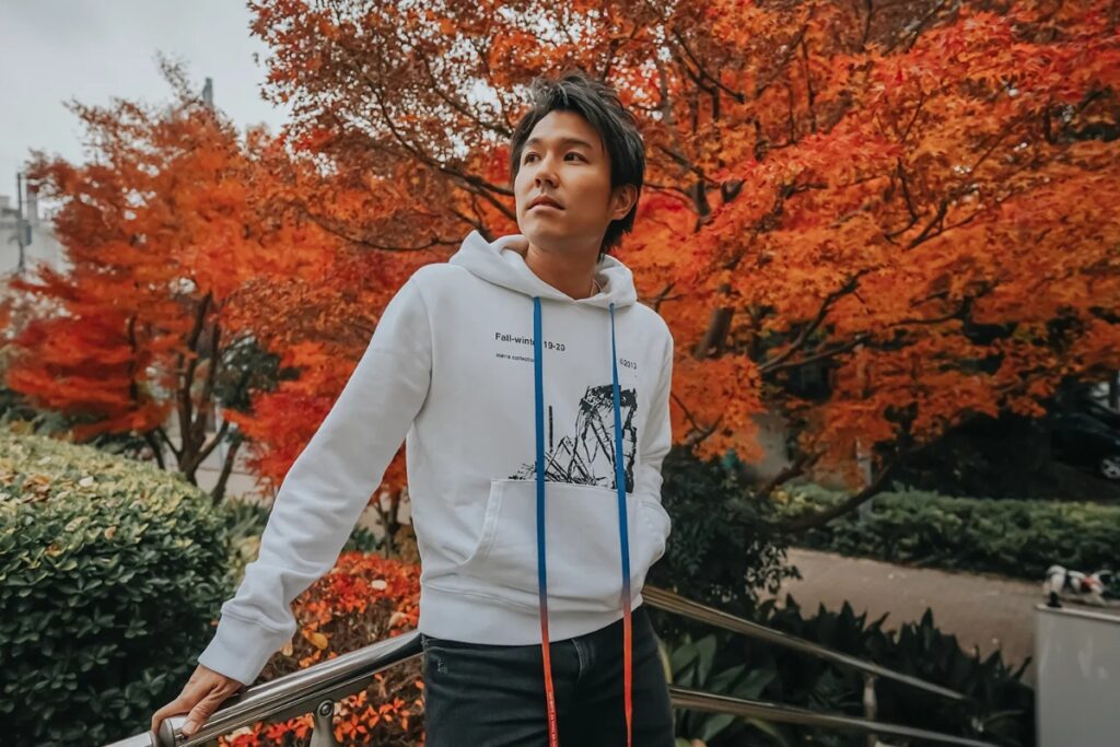 Stylish guest photographed in front of vivid autumn maple leaves by a Tokyo private photographer