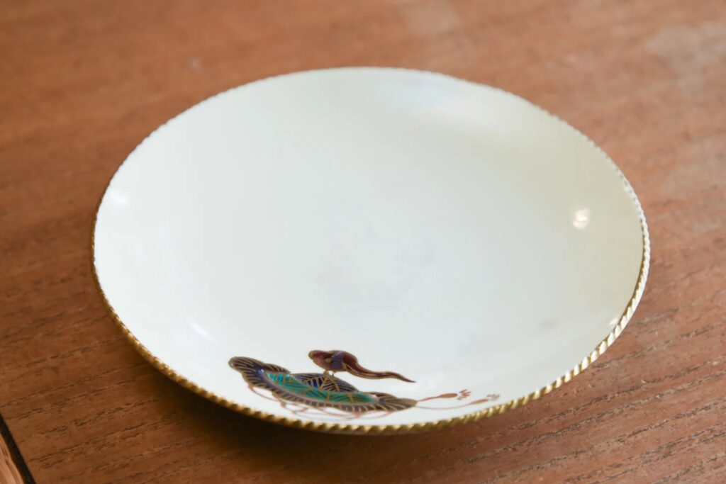 A finished 5-inch Kyouyaki ceramic plate decorated with traditional Japanese motifs, handcrafted during a Kyoto pottery workshop experience.
