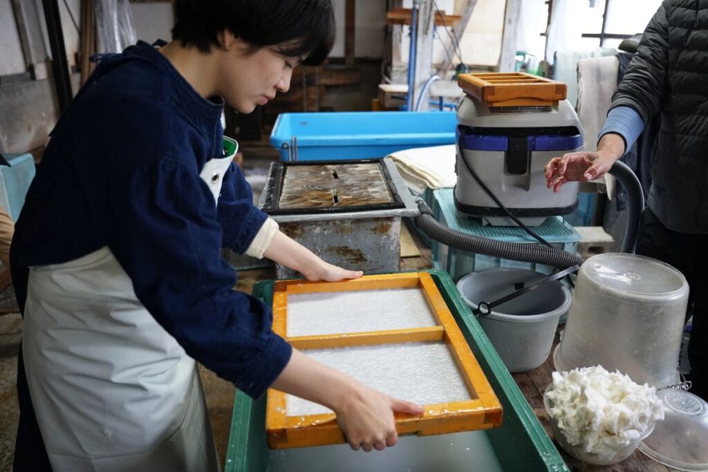 A traveler learns traditional Japanese papermaking techniques during a private Artisan Experience.