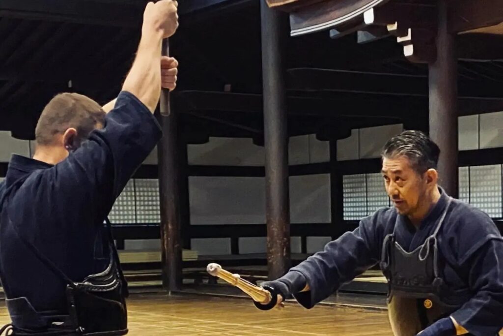 Instructor demonstrating a strike to a student inside the dojo