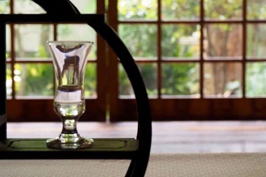 Elegant glassware displayed on a classic circular shelf inside a serene temple venue for the Uji matcha incense workshop.