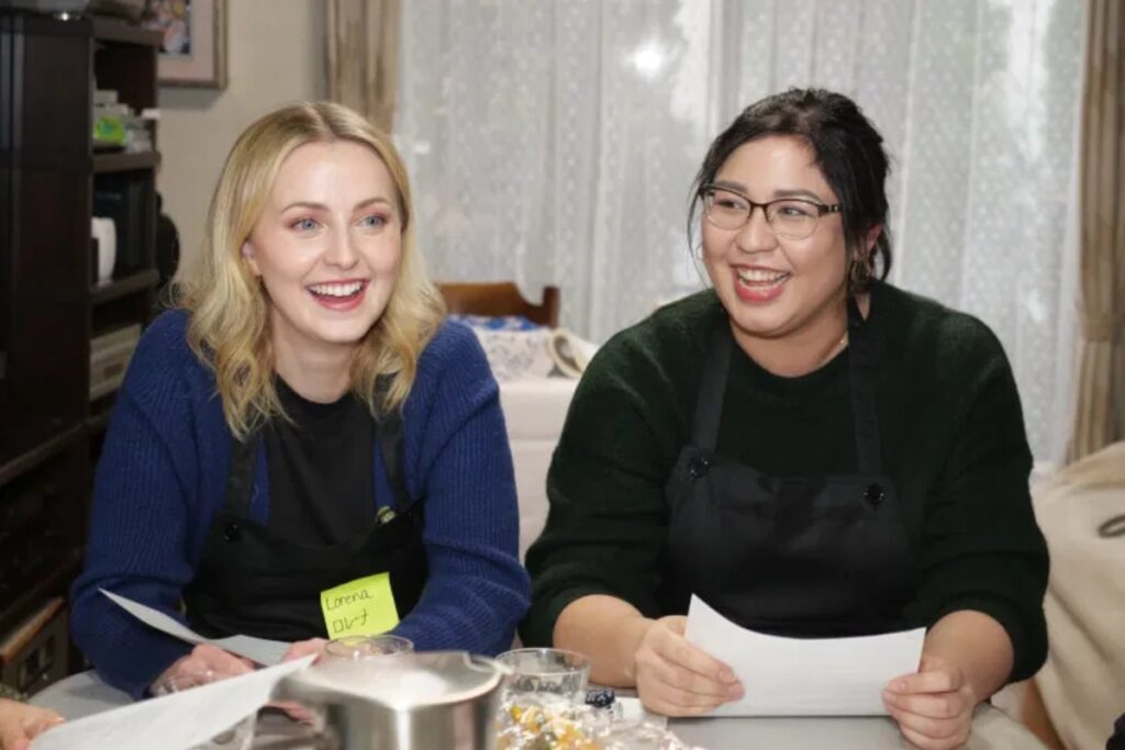 Smiling guest and friendly local teacher reading the recipe at a private Japanese home kitchen