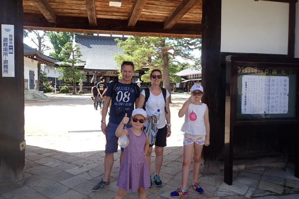A family exploring the rich architectural heritage and historic gate structures of the Hida region.
