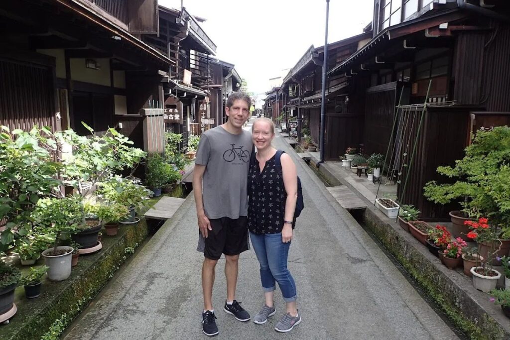 A couple walking through the beautifully preserved wooden merchant alleys of Takayama Old Town.