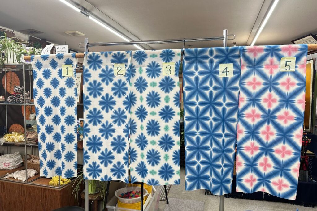 Traditional blue and white geometric patterned fabrics created during an Arimatsu Shibori tie-dyeing class.