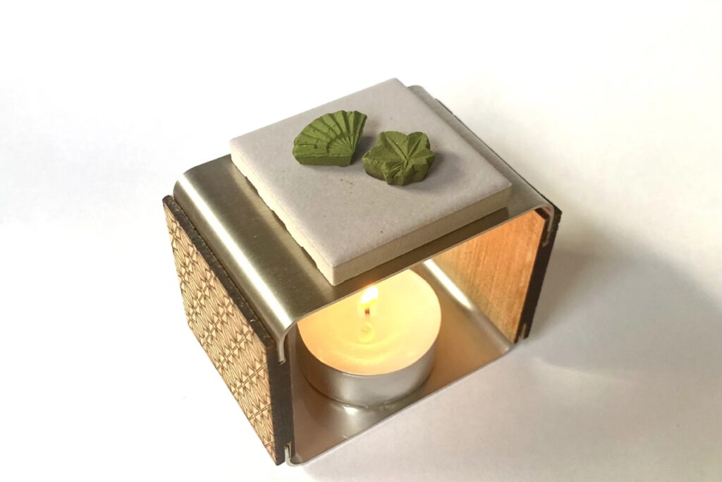 Mindfully burning smokeless green tea cones on a premium folding warmer included with the Uji matcha incense workshop.