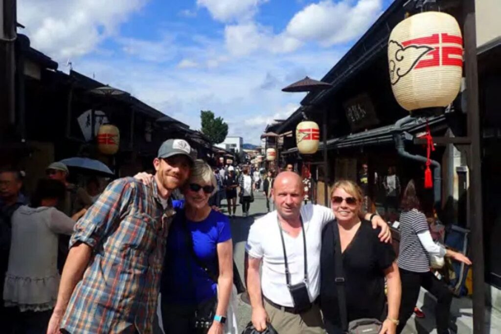 A private group of travelers exploring the historic merchant alleys of Takayama old town with their guide.