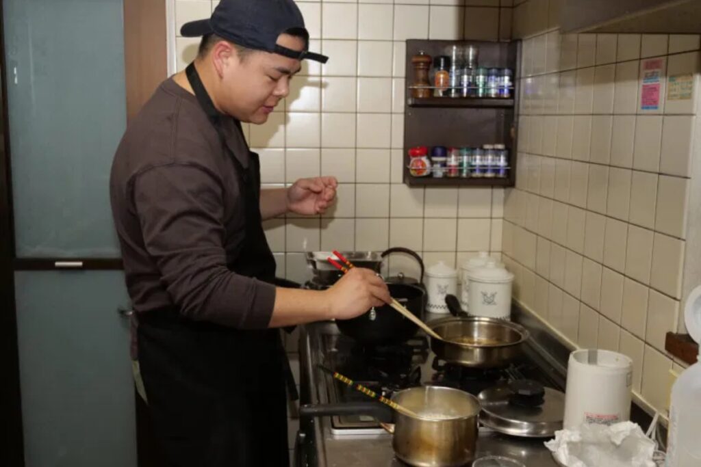 Local host cooking plant-based dishes on the stove in an authentic Japanese home kitchen in Tokyo