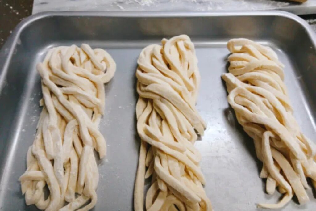 Three portions of freshly cut handmade udon noodles ready to cook at a Tokyo udon making class