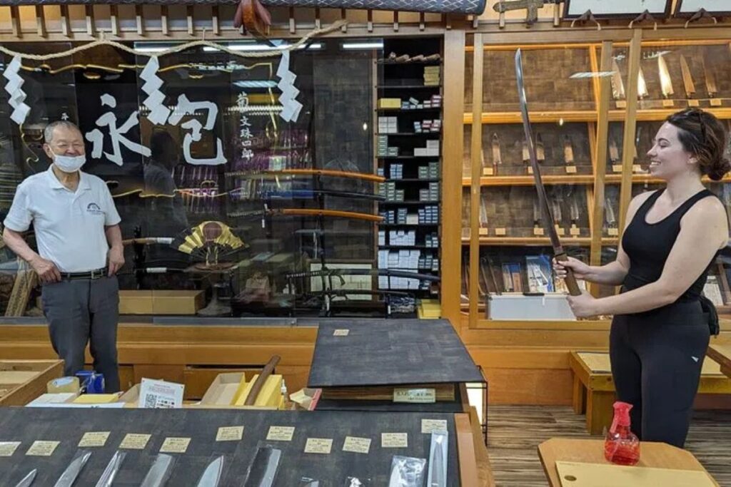 Traditional cooking knives displayed on wooden shelves inside the historic Kikuichi Knife Company.