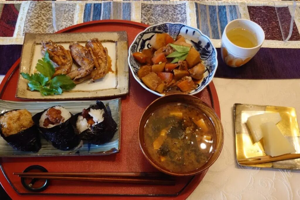 Traditional Japanese home cooking with teriyaki, rice balls, and simmered vegetables in Nagoya
