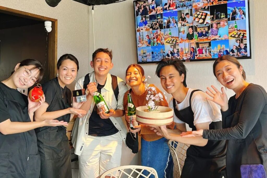 International guests and friendly hosts celebrating together at a Tokyo sushi making experience in Asakusa