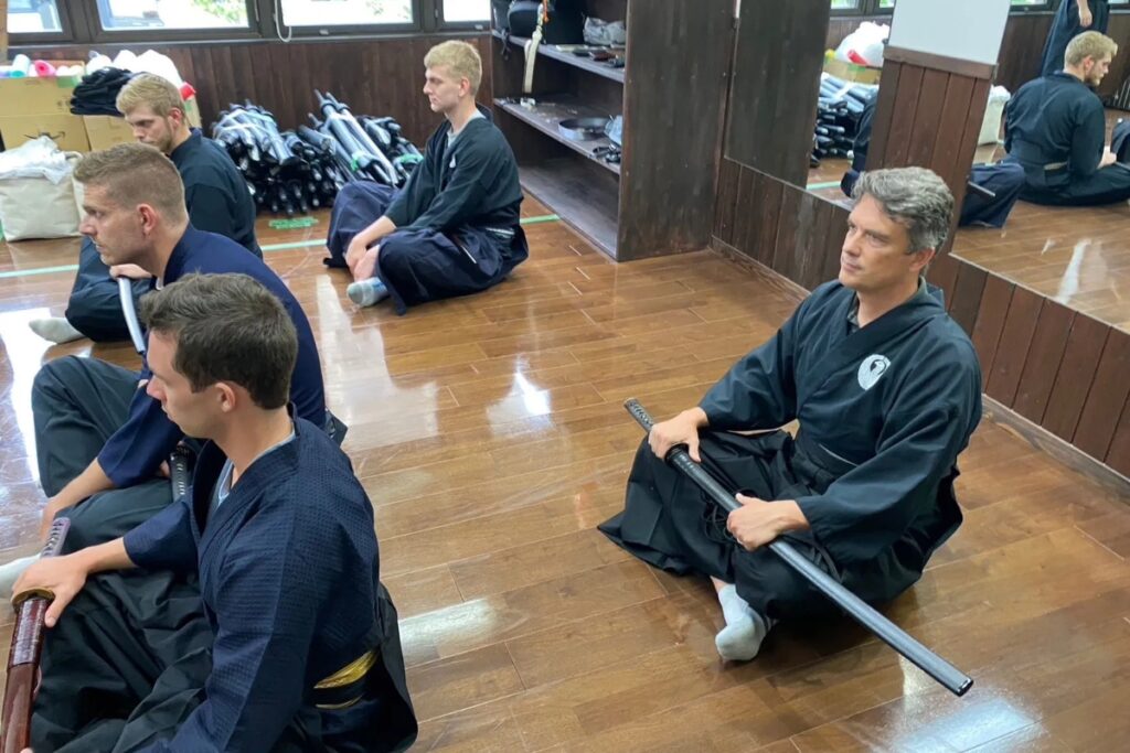 Guests sitting in seiza holding swords during a traditional Tokyo Iaido experience class