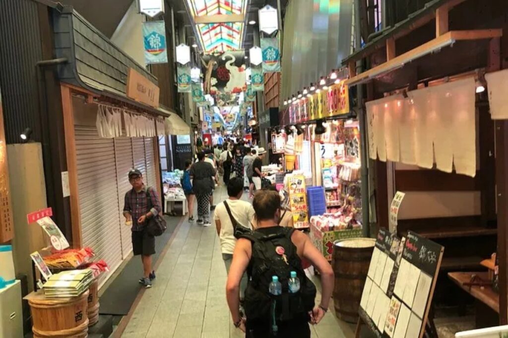 Visitor exploring the covered stalls of Nishiki Market in central Kyoto