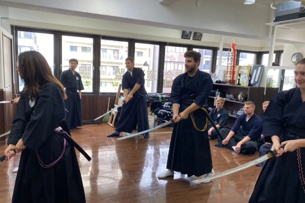 International guests practicing samurai sword movements together at a Tokyo Iaido experience