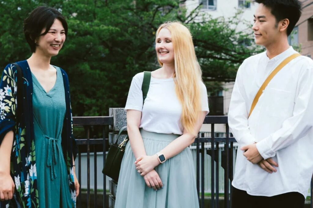 Local guide Manami chatting warmly with international guests during a Tokyo temple guided tour