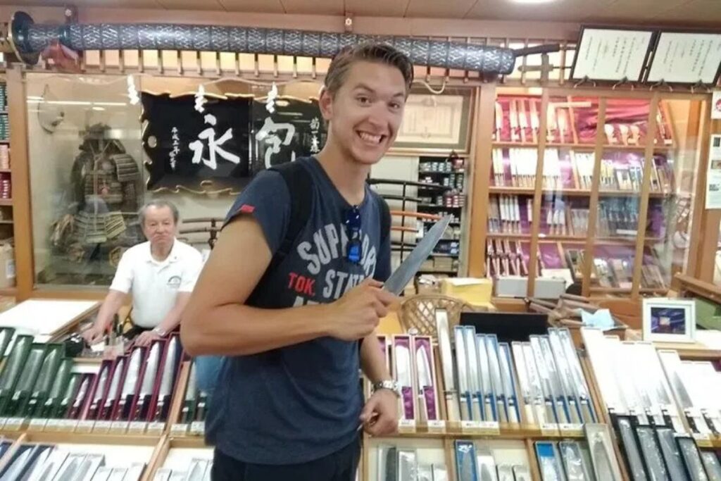 A traveler examining traditional Japanese cutlery on a Nara sightseeing tour stop.