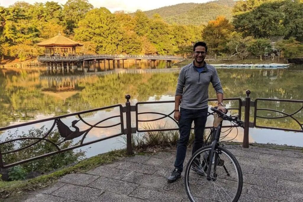 A cyclist standing next to a peaceful pond during a Nara highlights bike tour.