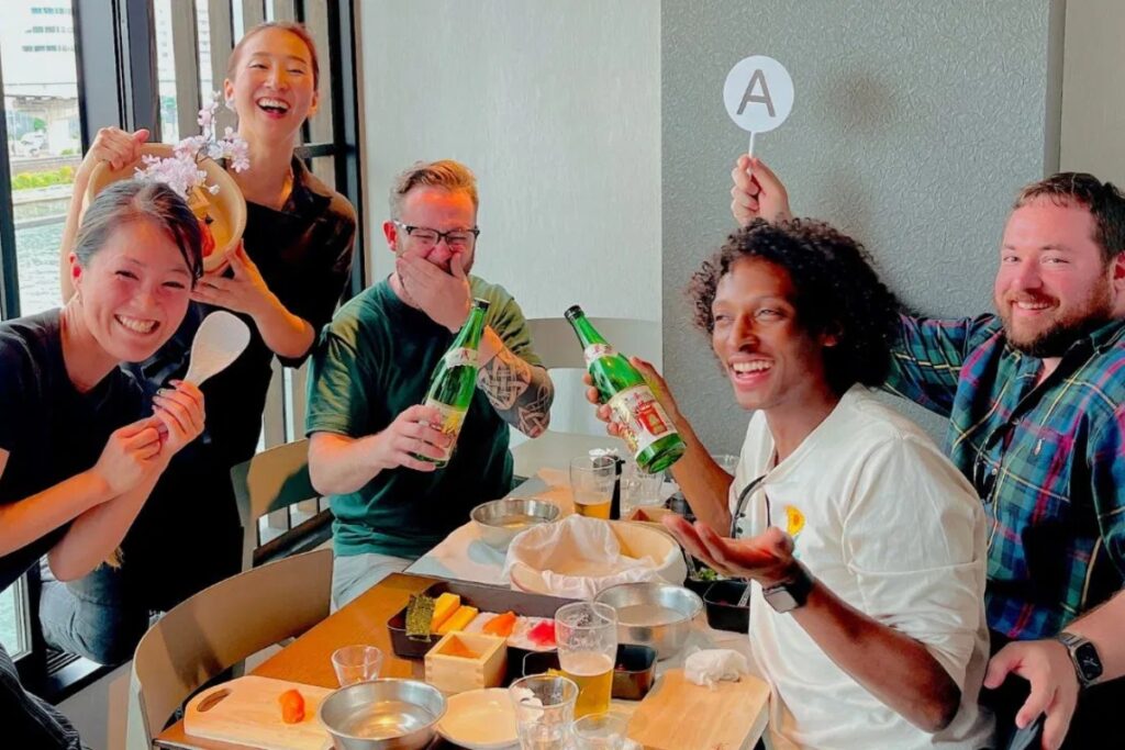 Cheerful guests raising sake and laughing during a Tokyo sushi making experience in Asakusa