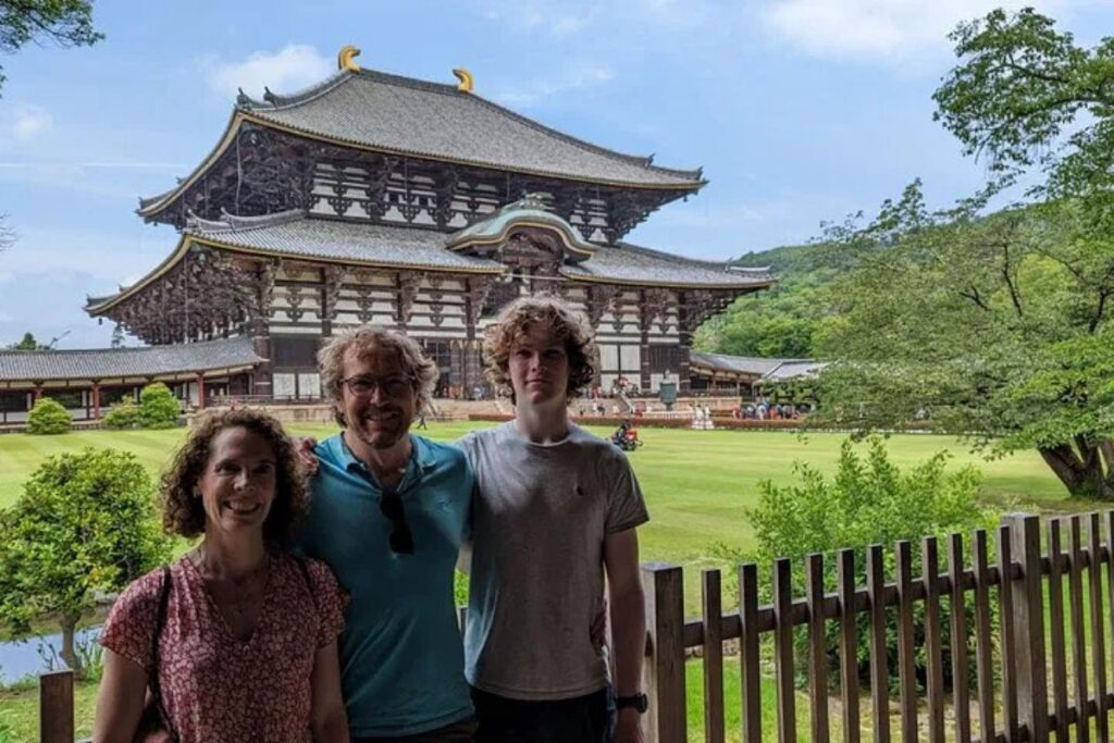 Visitors standing outside the massive wooden Daibutsuden temple structure.