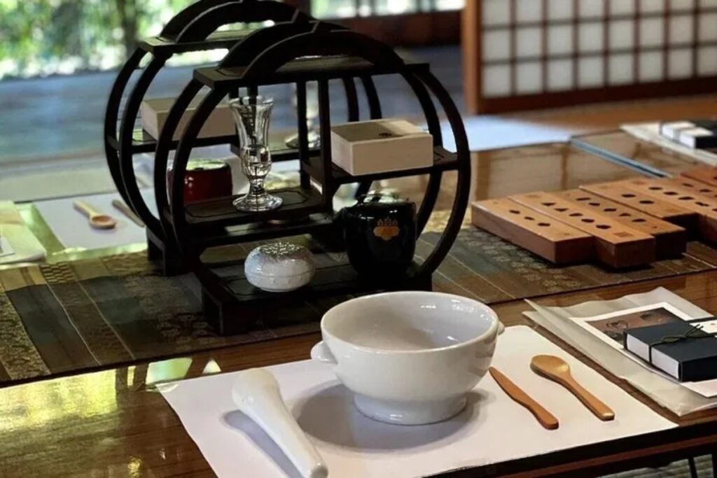 A meticulously prepared workshop table featuring traditional blending bowls and utensils inside a temple for the Uji matcha incense workshop.