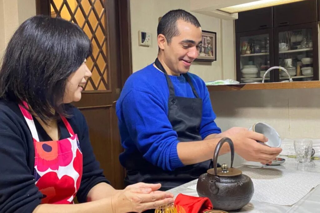 Local teacher and guest enjoying a casual matcha tea ceremony with an iron kettle in a Tokyo home