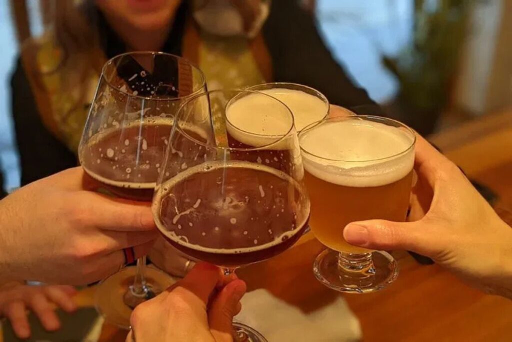 Friends clinking glasses filled with craft beer in a celebratory toast.