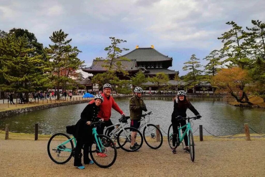 Travelers stopping on their bicycles in front of the grand Todaiji Temple building on a Nara family bike tour.