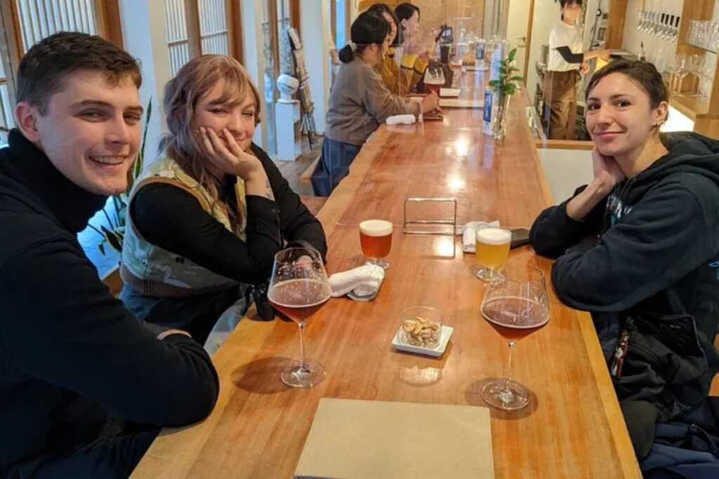 A group of travelers relaxing with craft beer at a local microbrewery during a Nara food walking tour.