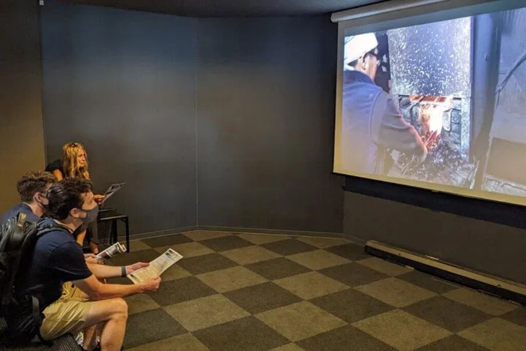 Guests watching an educational presentation about local craftsmanship history.