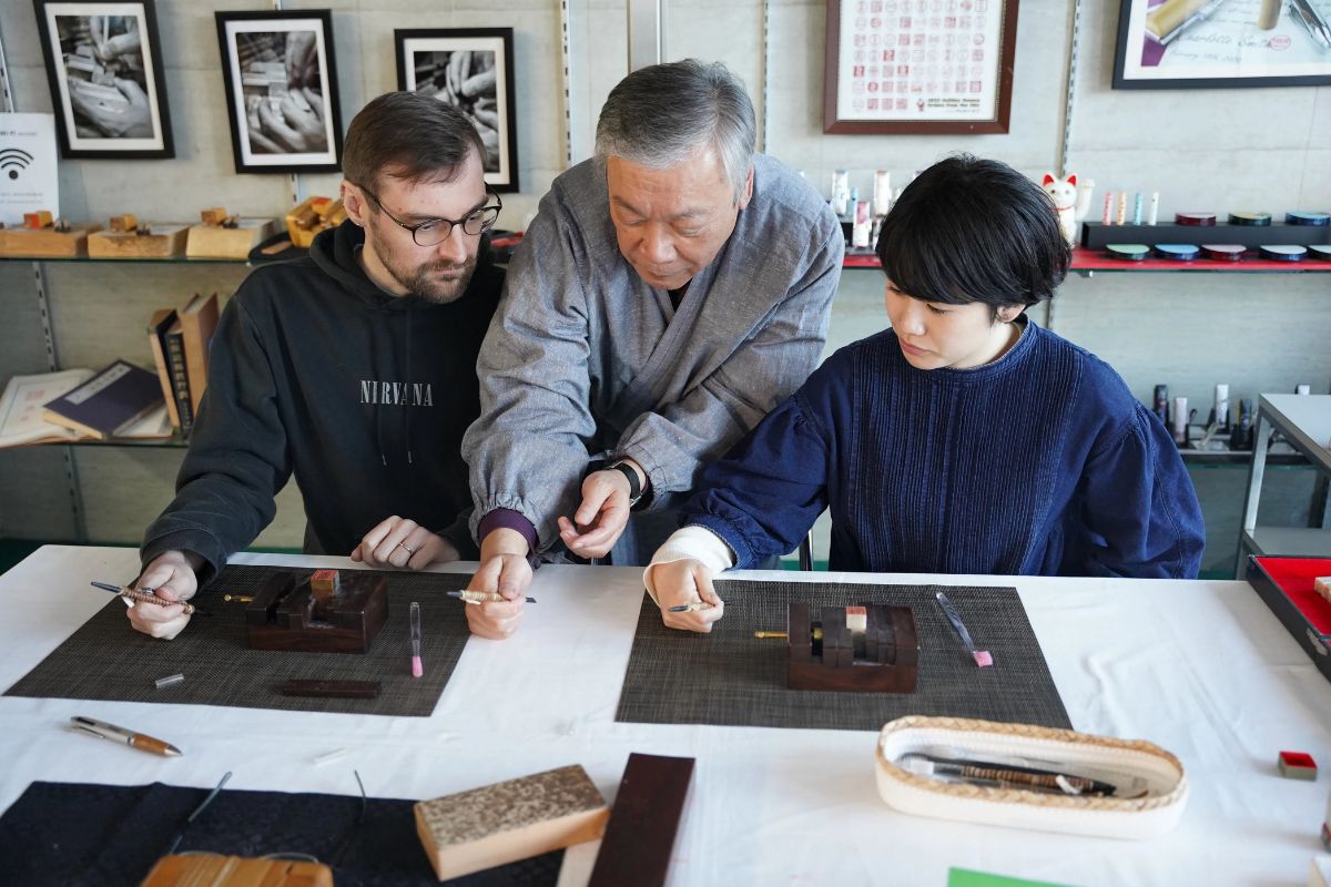An master artisan showing custom stone seals to guests