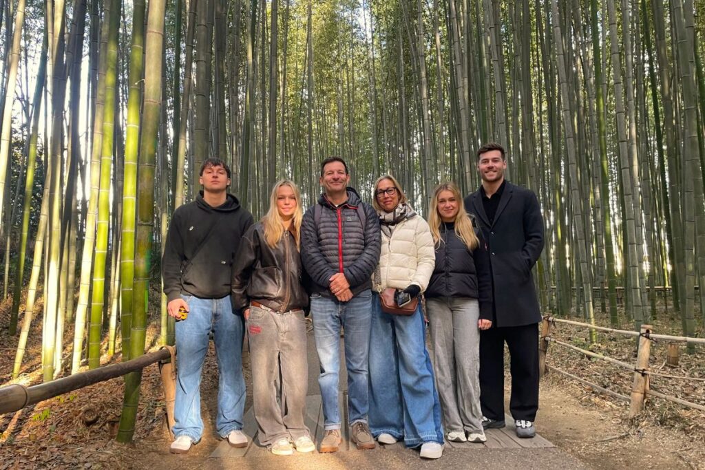 A group of six travelers exploring a beautiful bamboo forest together on a shared arashiyama walking tour.