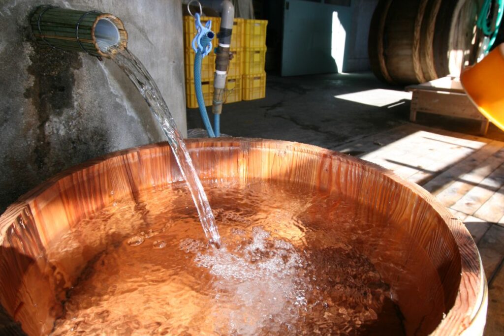 Pure brewing water pouring into a traditional wooden well