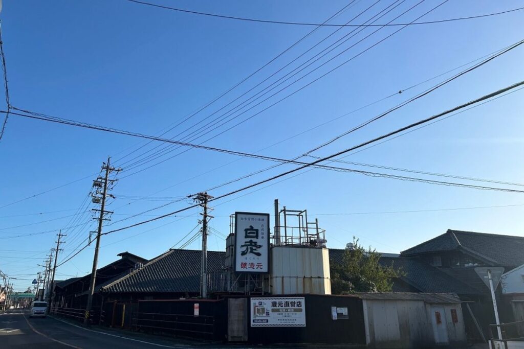 The exterior facade and historic chimney of the 170-year-old heritage brewery that hosts the sake label making experience.