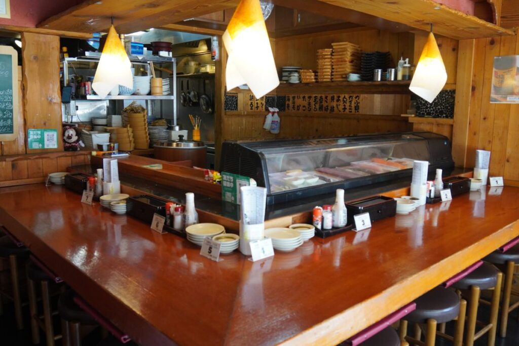 The traditional wooden counter seating and preparation area inside the authentic restaurant venue where the Nagoya sushi making experience takes place.