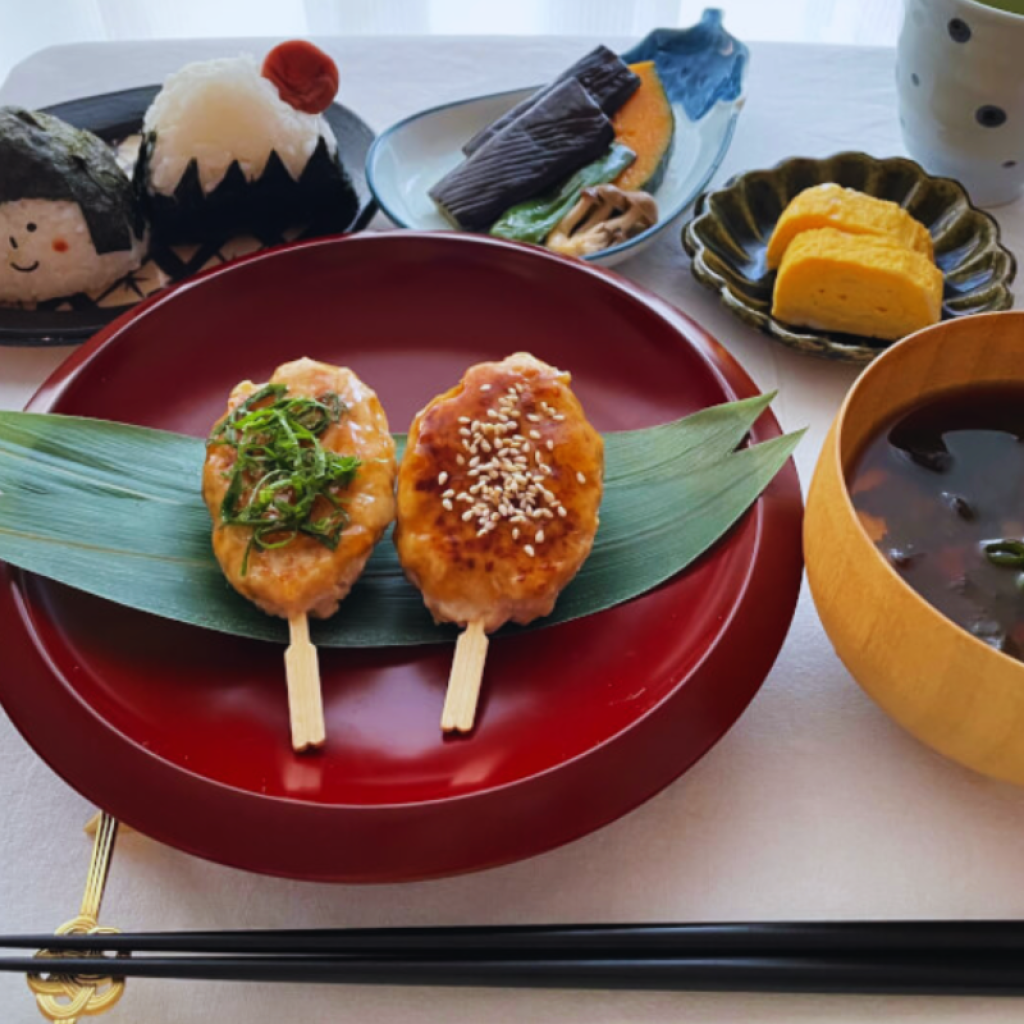 Traditional Japanese Ichiju Sansai meal set featuring grilled miso-glazed rice skewers served on red lacquerware.